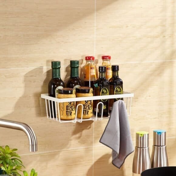 Bottles of sauces and condiments on a wall-mounted rack in the kitchen.