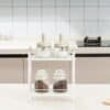 Minimalist kitchen spice jars on a white rack in modern kitchen setting.