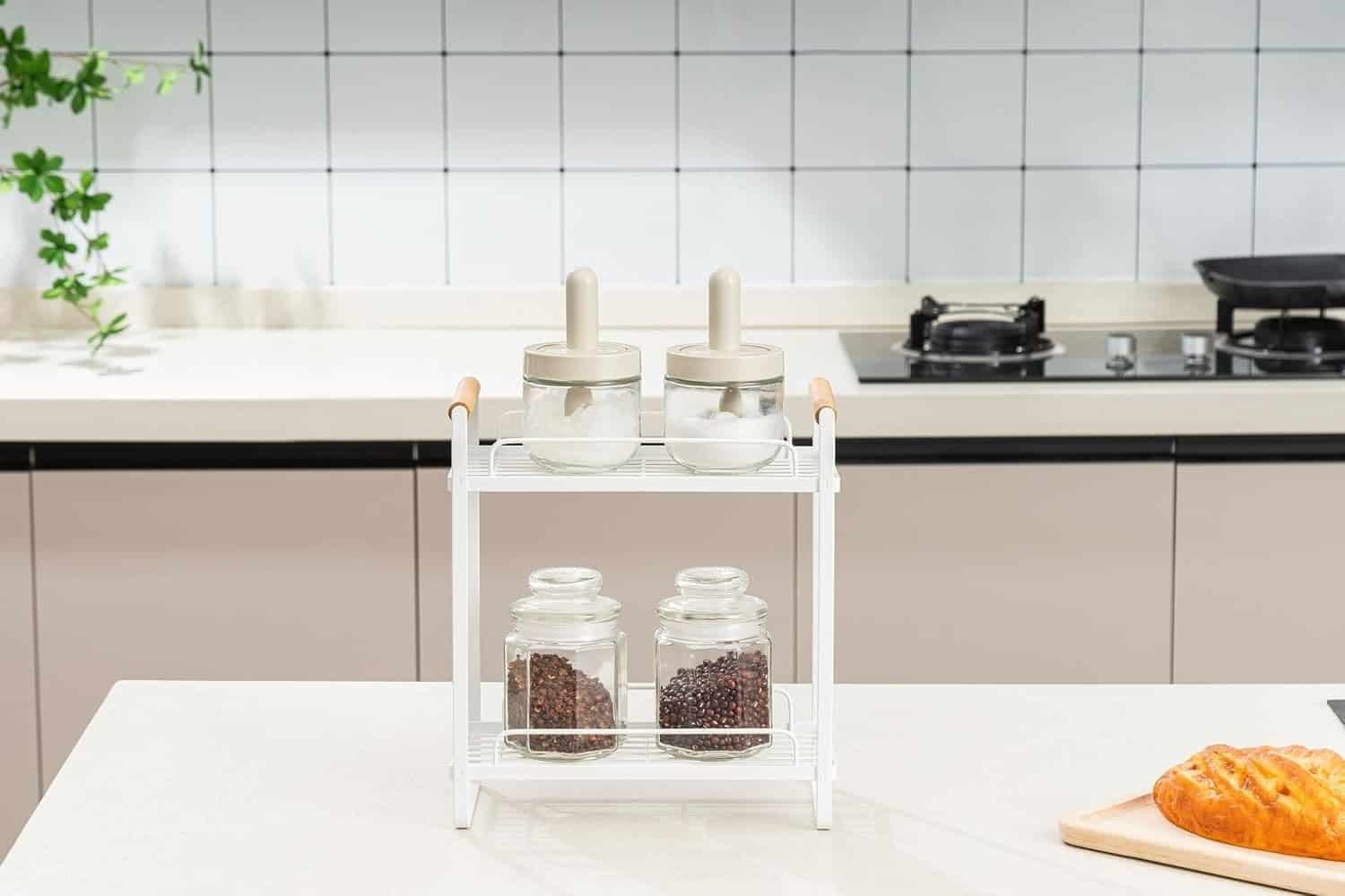 Minimalist kitchen spice jars on a white rack in modern kitchen setting.