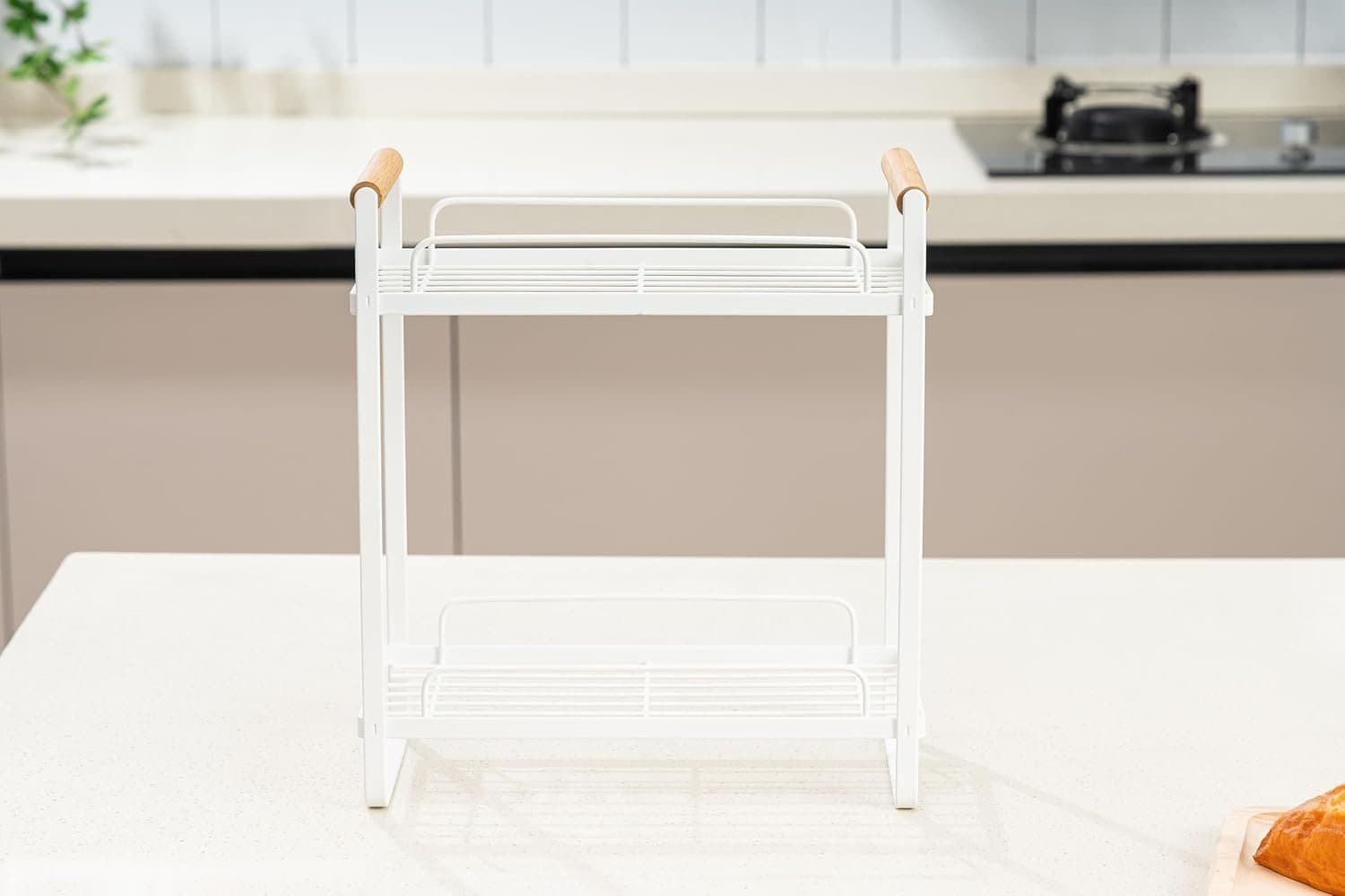 White kitchen dish drying rack with wood handles on a clean countertop.