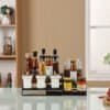 Organized spice rack with glass jars and condiment bottles on kitchen countertop.