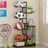 Black ball rack organizer neatly storing footballs and basketballs in a modern room