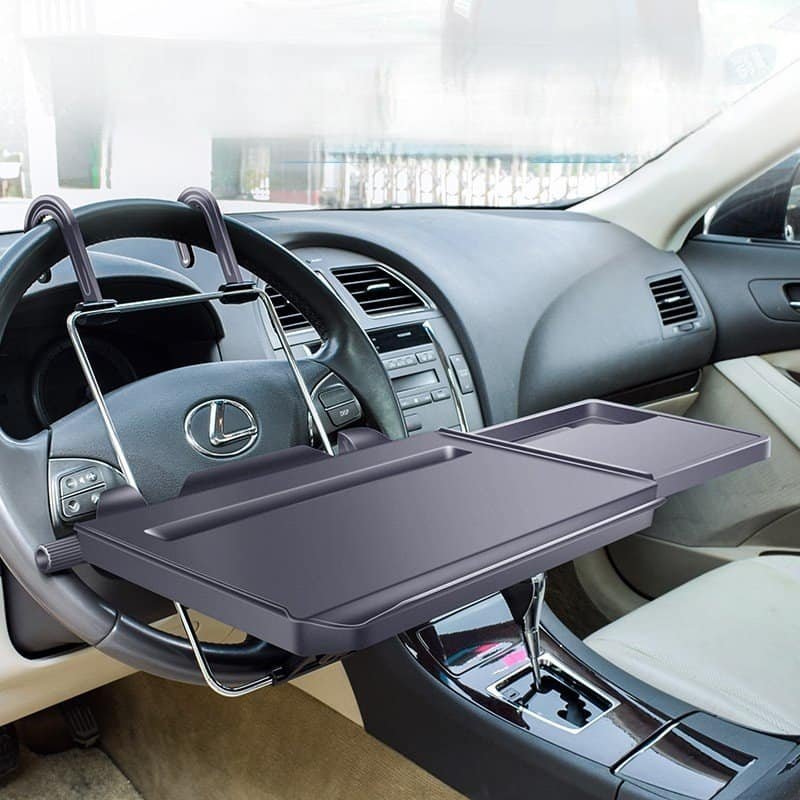 Foldable car tray table mounted on steering wheel for work and meals in the front seat.