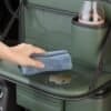 green leather back seat organizer with cup holder, tray table, and storage pockets.