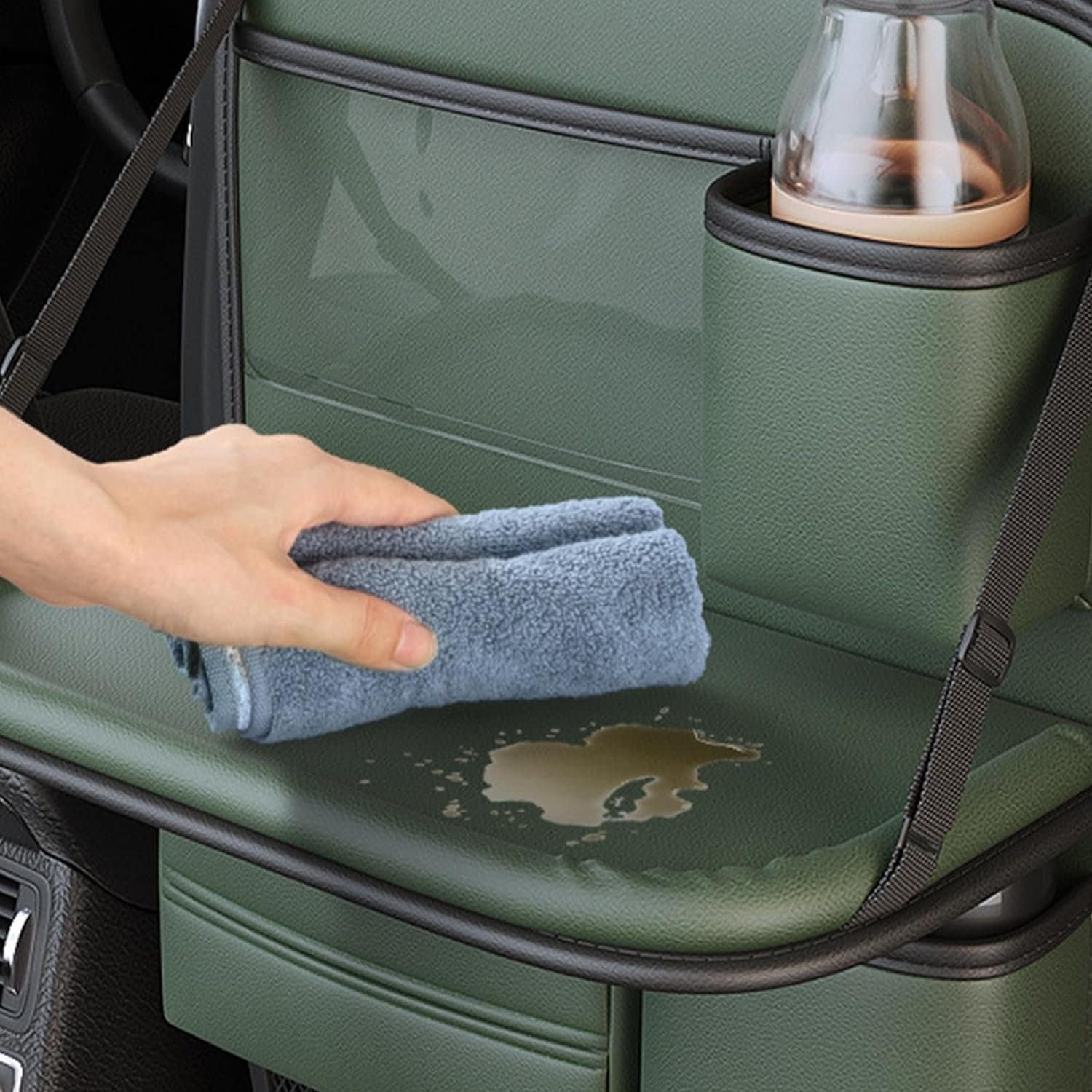 green leather back seat organizer with cup holder, tray table, and storage pockets.