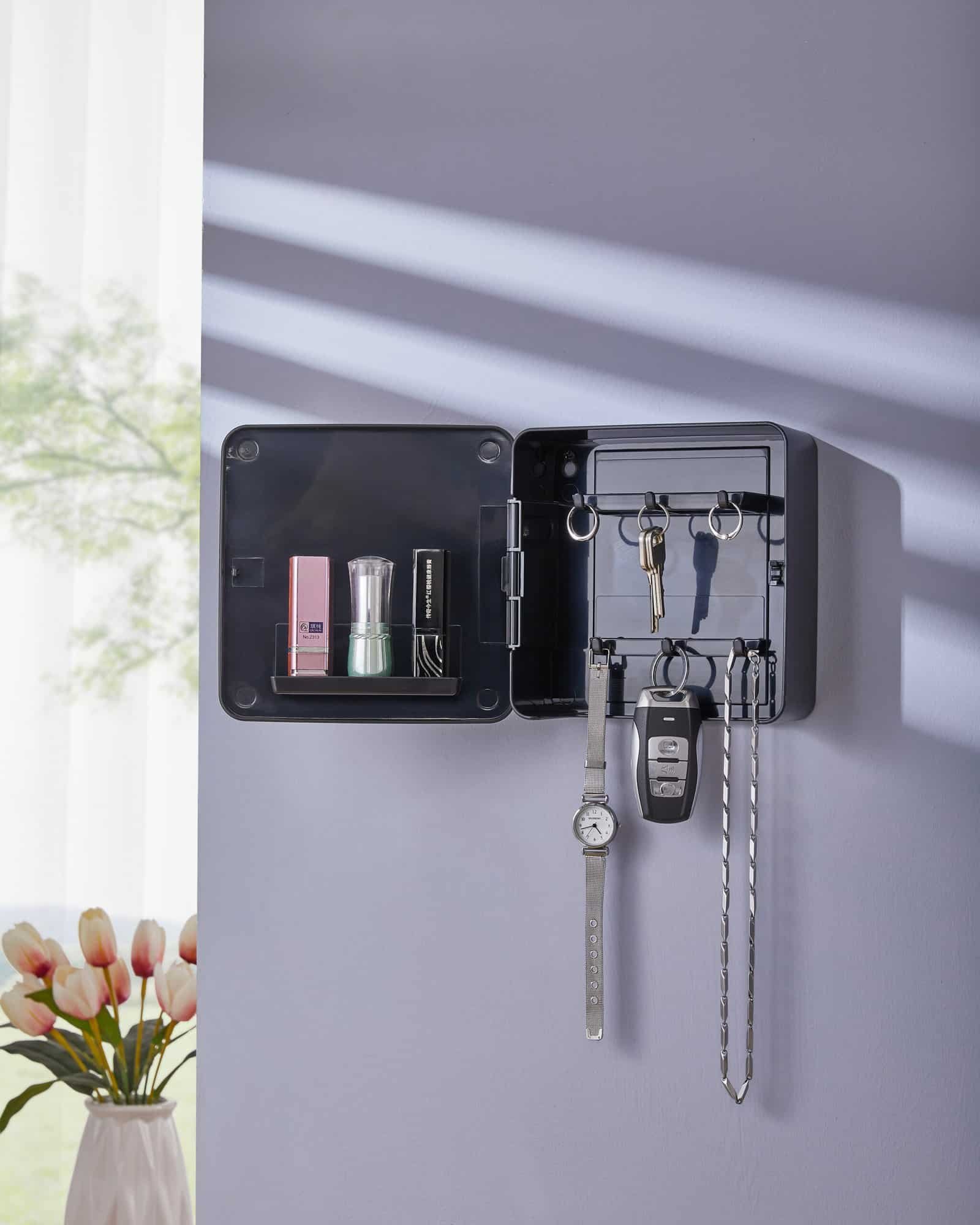 The black organizer box opened, revealing internal key hooks and shelves storing perfume and lipstick.